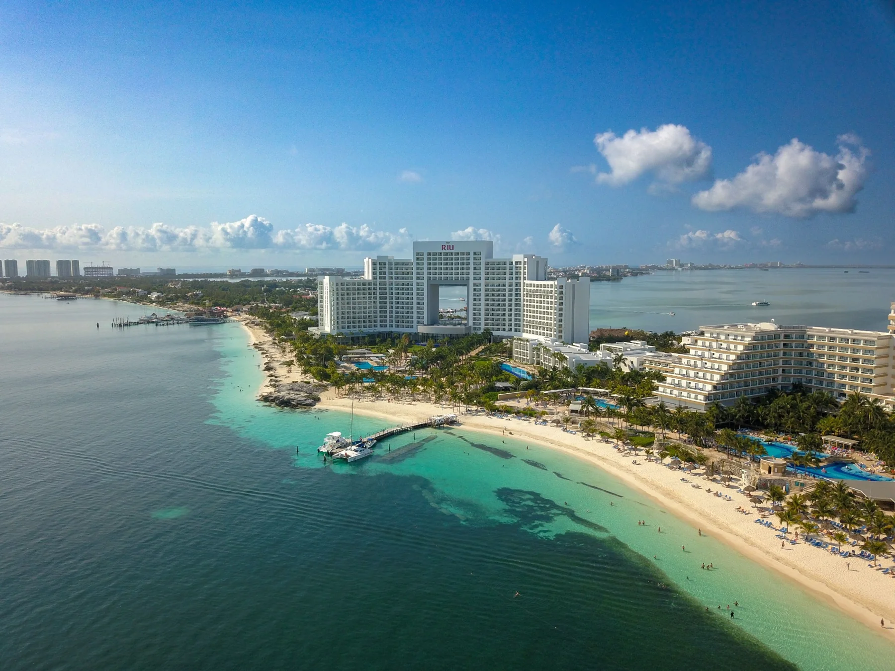 Aerial view of beachfront hotels between turquoise water and a lagoon