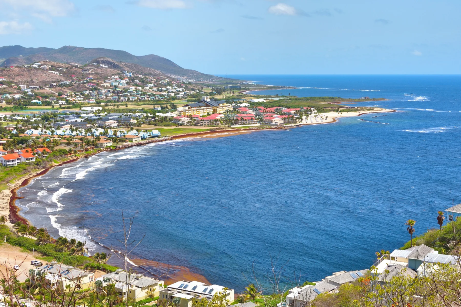 Wide coastal bay with hillside buildings and blue water
