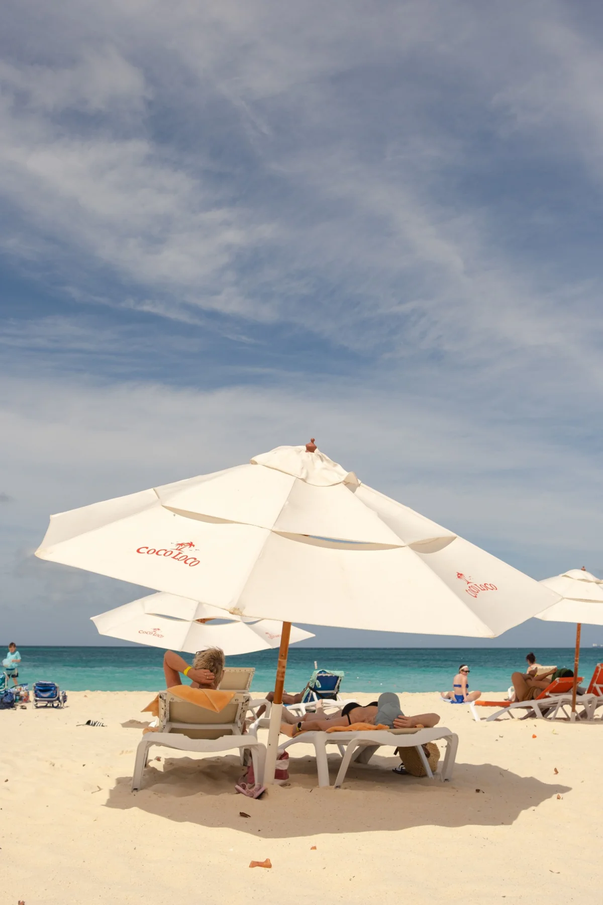 Sun loungers and white parasols on a sandy beach