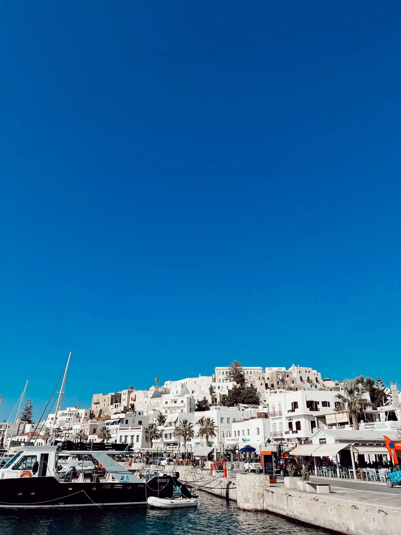 White buildings around a small harbour beneath a deep blue sky