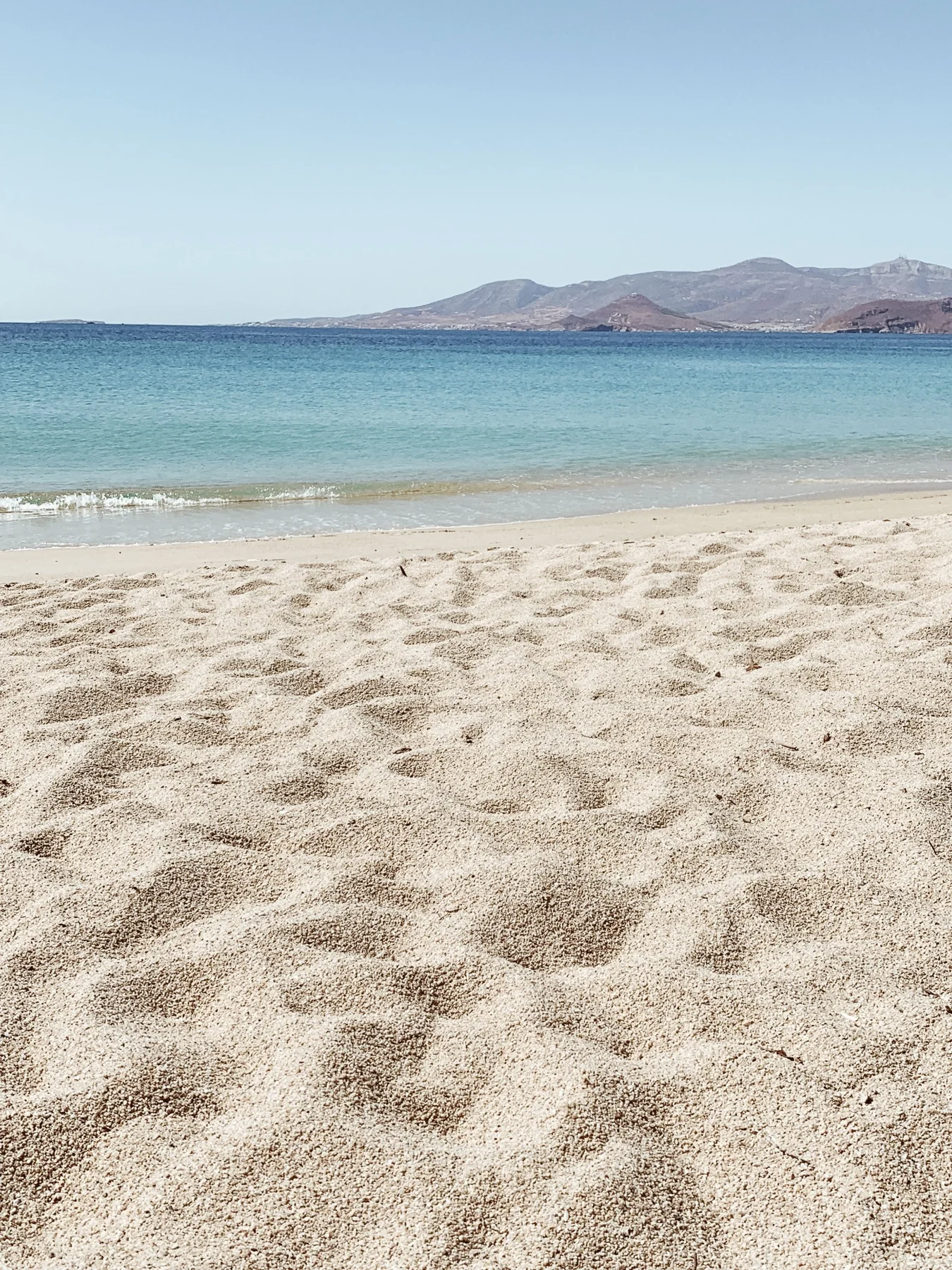 Open sandy beach with low hills in the distance